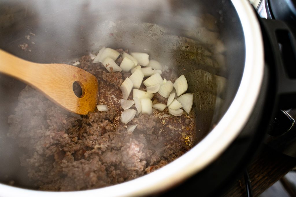 Add the onions to cook with the sausage in the Instant Pot